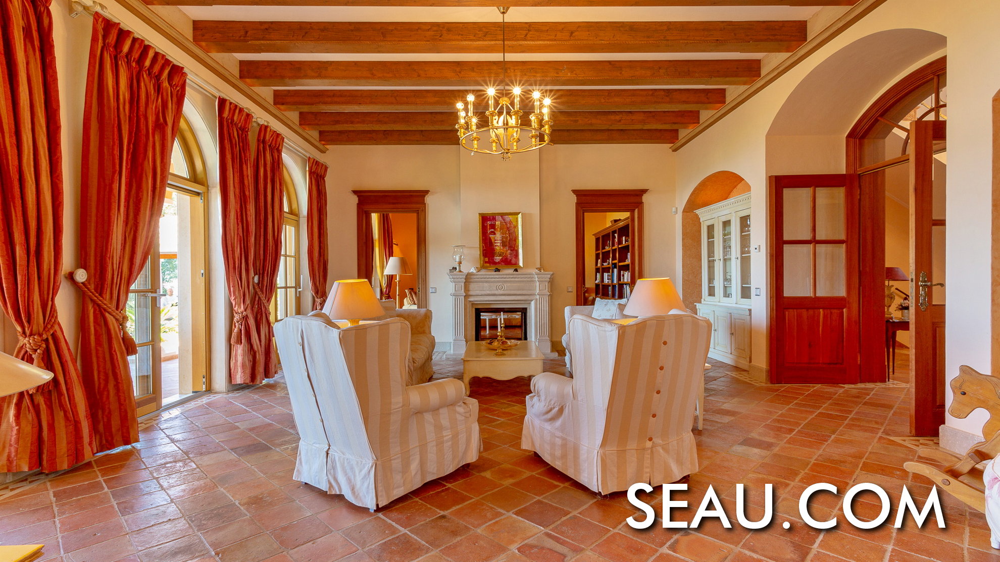De woonkamer is een gastvrije ruimte, omgeven door edele hout- en natuursteenmaterialen.